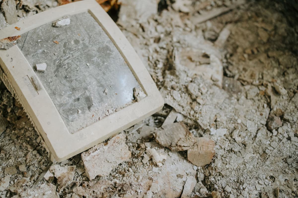 an old chunky beige computer monitor balanced on a rusty metal stool