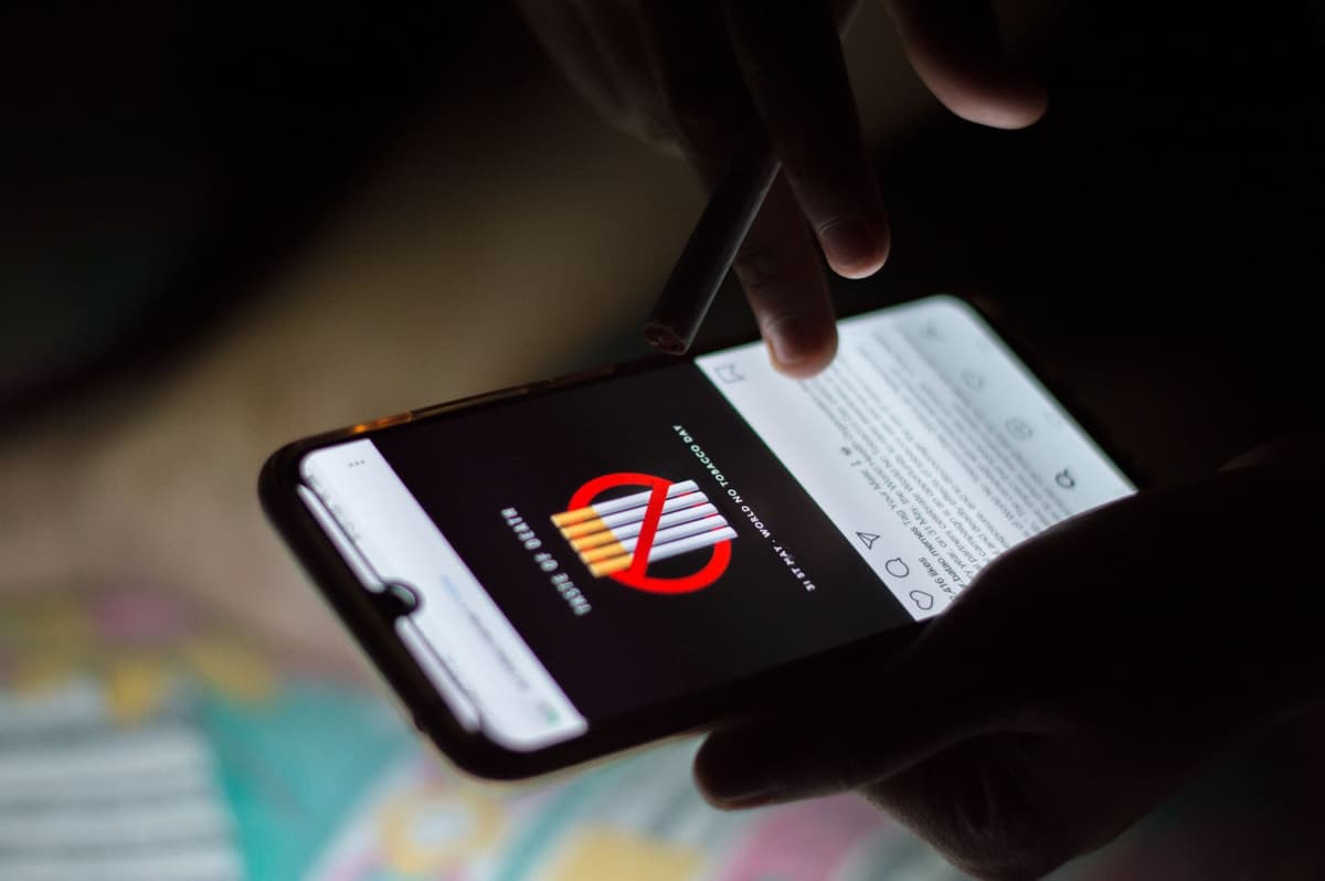 a person holding a glowing smartphone in a dark room