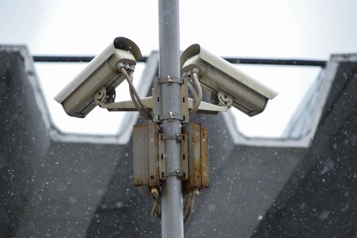 close-up of a sleek security camera scanning a crowd near stadium gates