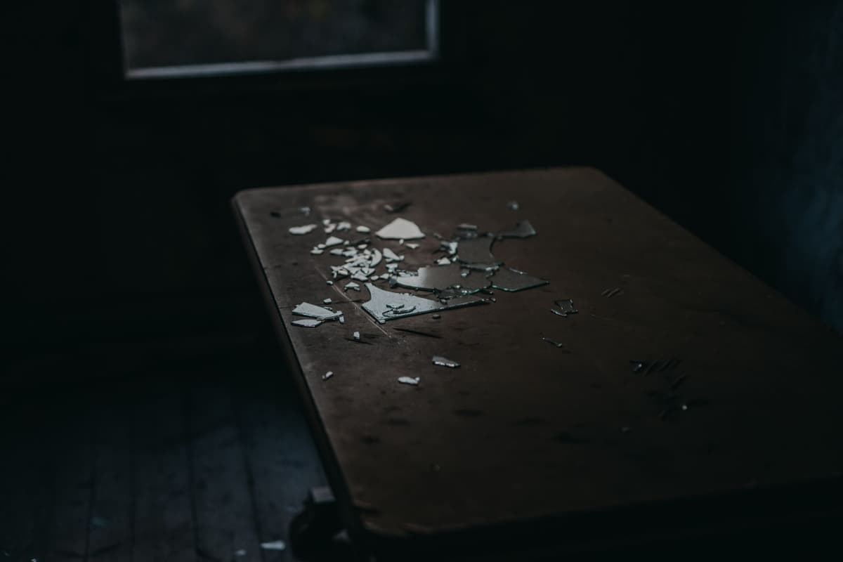 a single silver key sitting on an empty glass table
