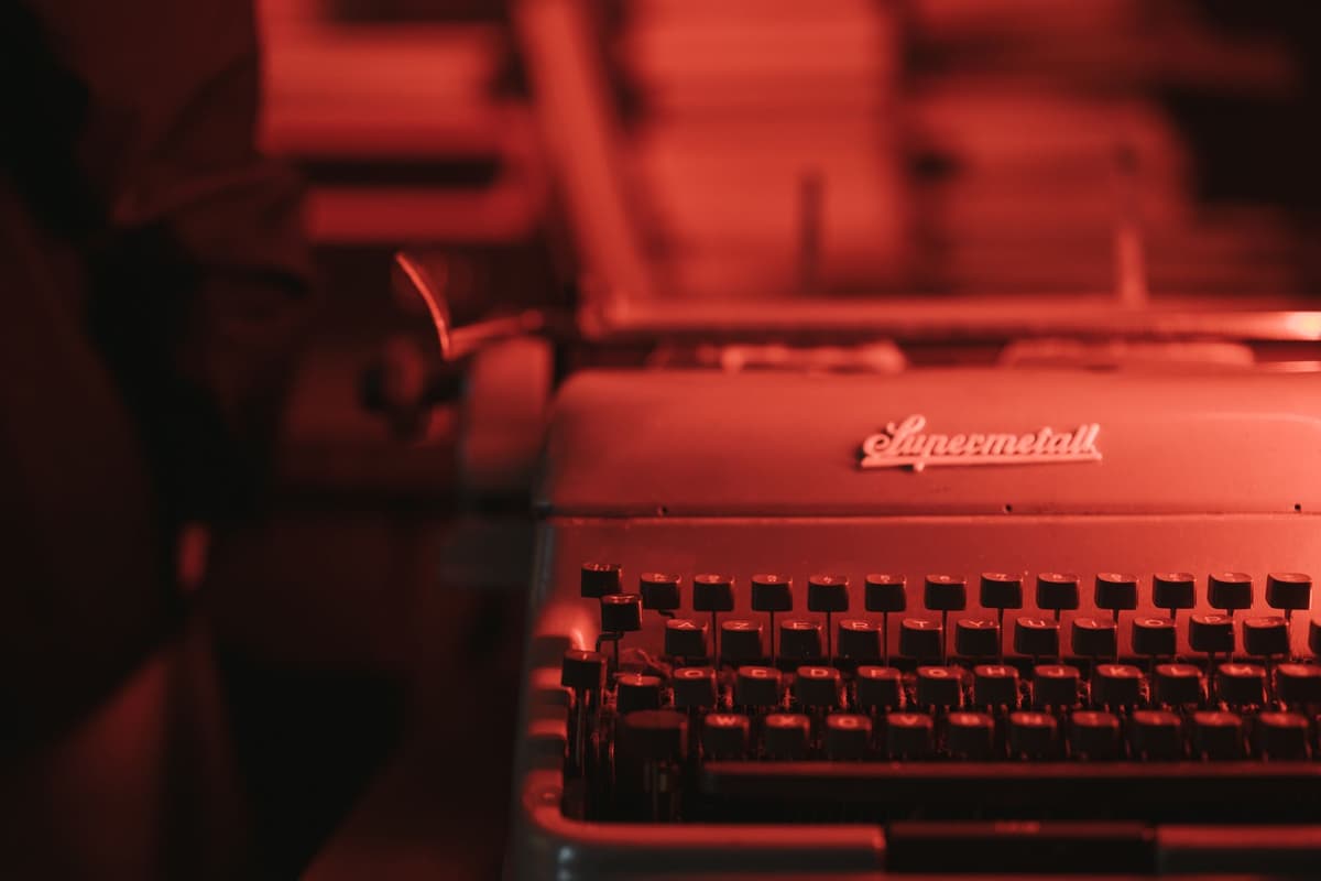 a dusty vintage typewriter with a glowing fiber optic cable emerging from the carriage