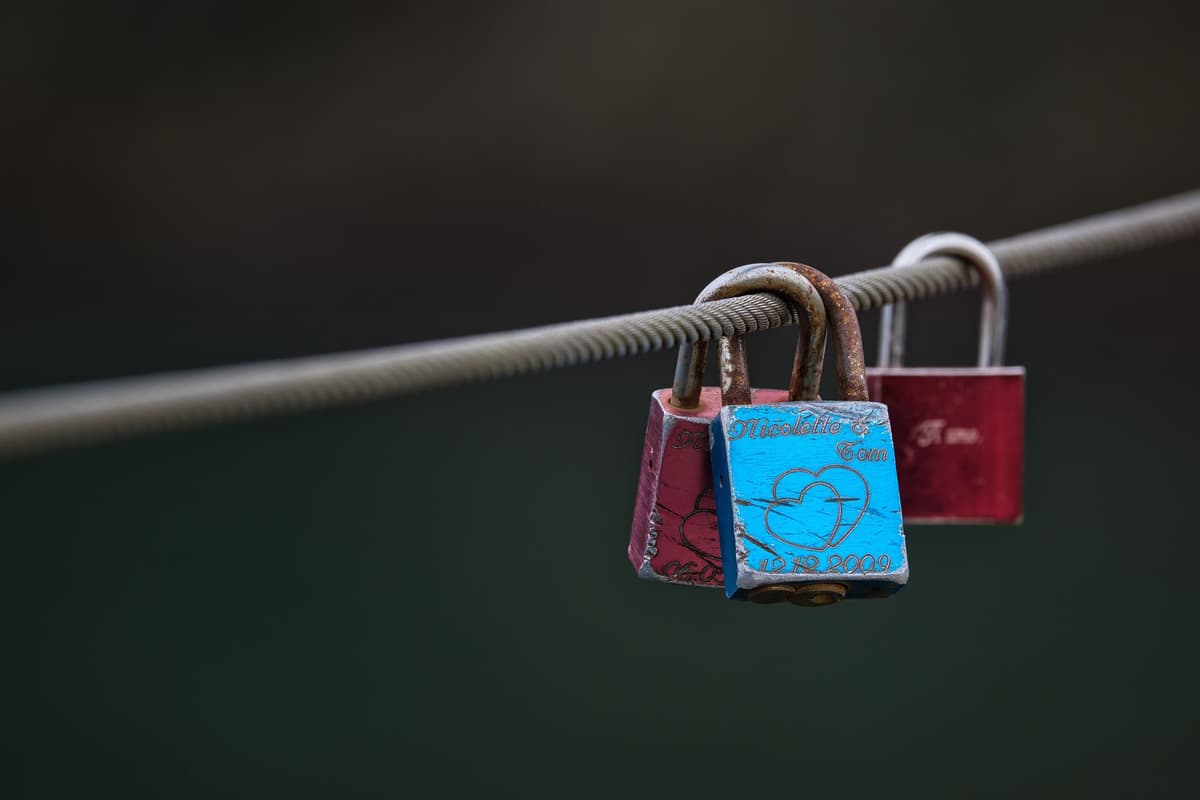 a shiny silver padlock sitting on a pile of data cables