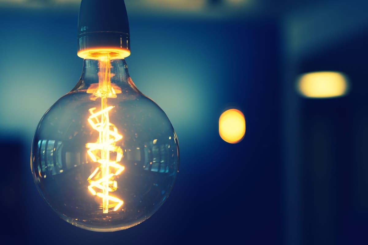 a single lightbulb glowing in a room full of mirrors