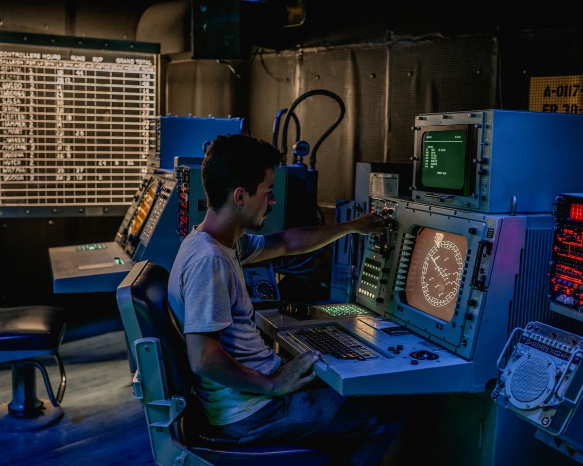 a person staring at a glowing complex dashboard in a dark room