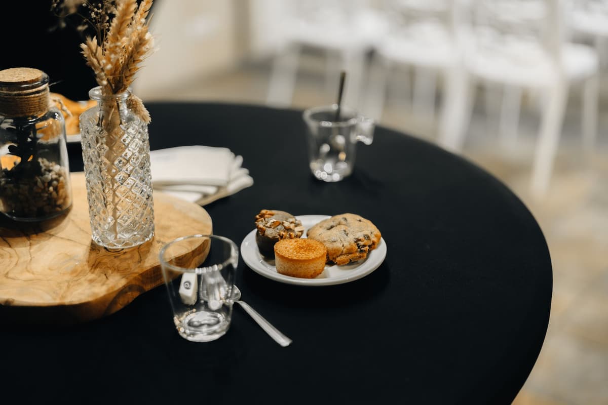 a single steaming baked potato sitting on a black velvet tablecloth