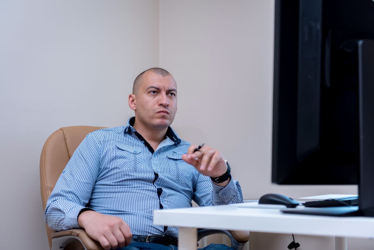 a man staring suspiciously at a computer monitor
