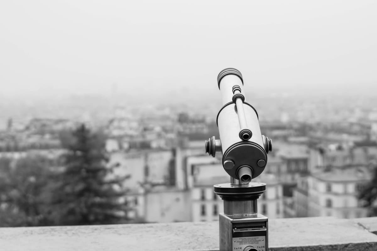 a close up of a vintage telescope pointing out a dusty window