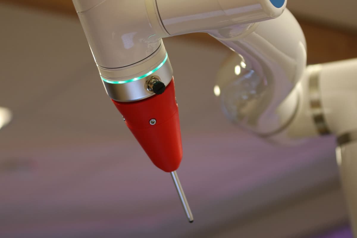 a surgical robot arm holding a standard gaming controller