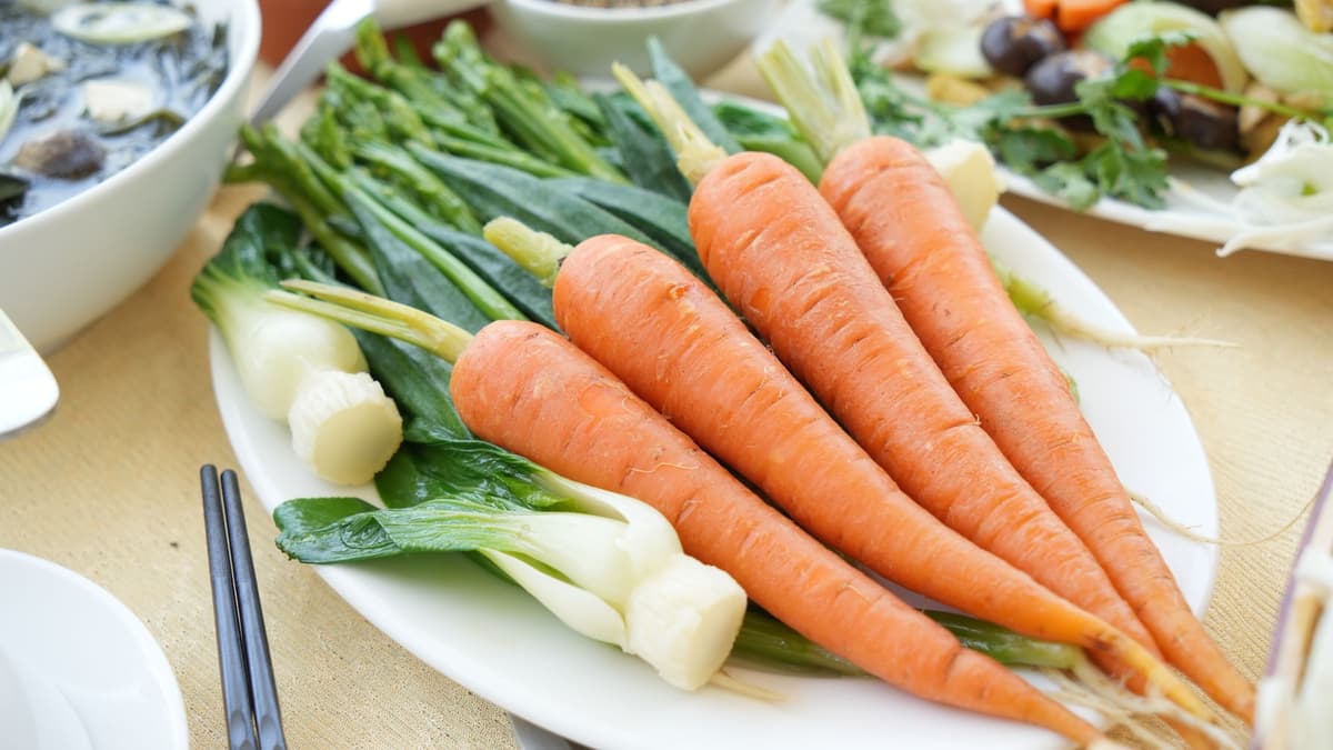 a single lonely carrot sitting on a silver platter