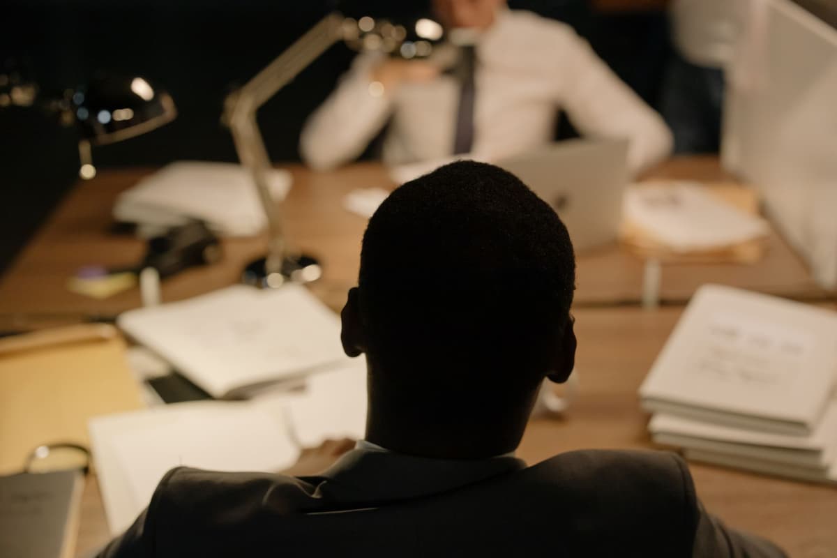 a single white document glowing on a dark cluttered desk