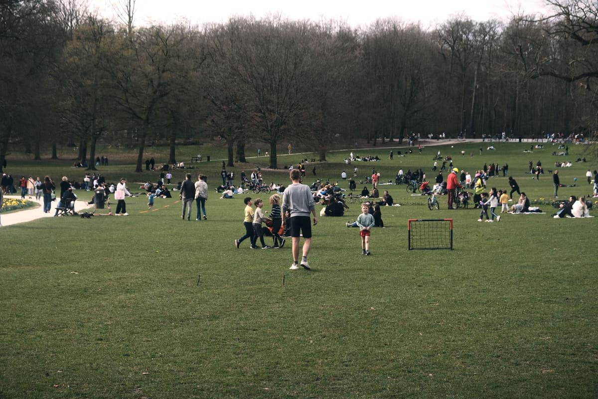 a group of people playing soccer on a large lawn