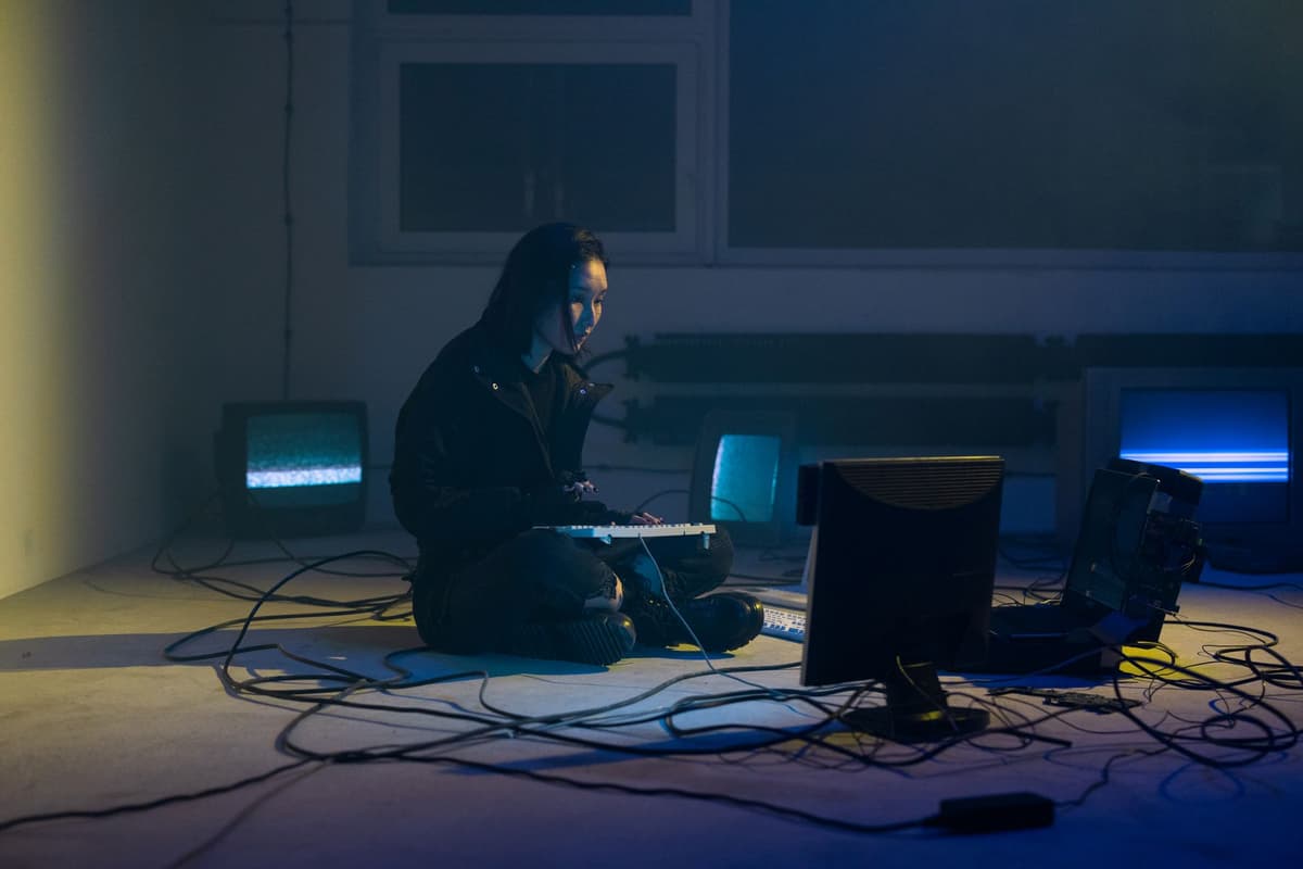a person staring at three glowing monitors