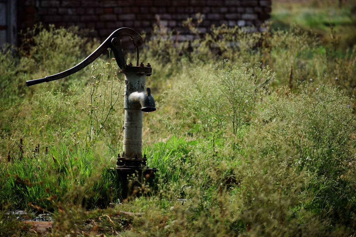 a row of industrial water pumps in a sunlit field