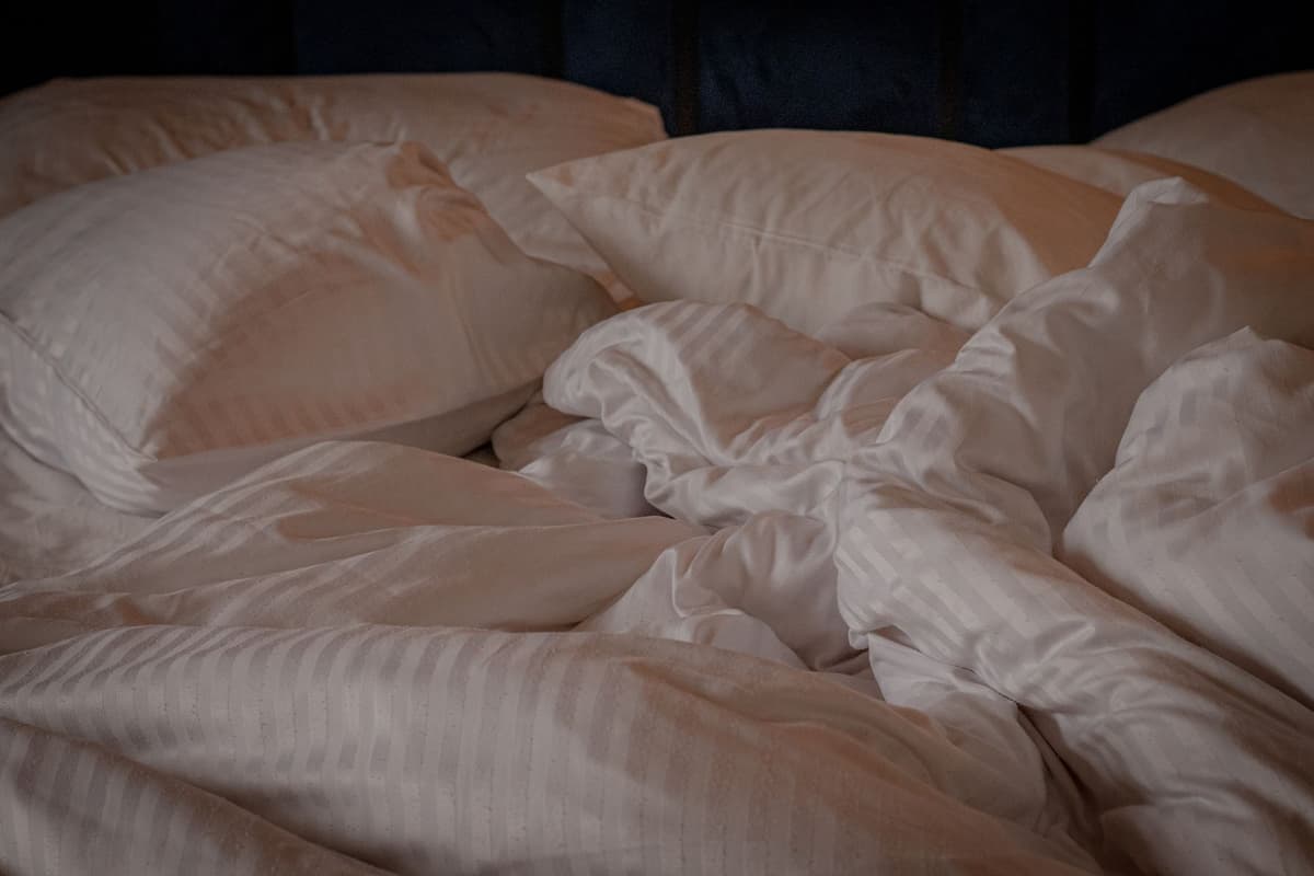 a high-end stopwatch resting on a messy unmade bed