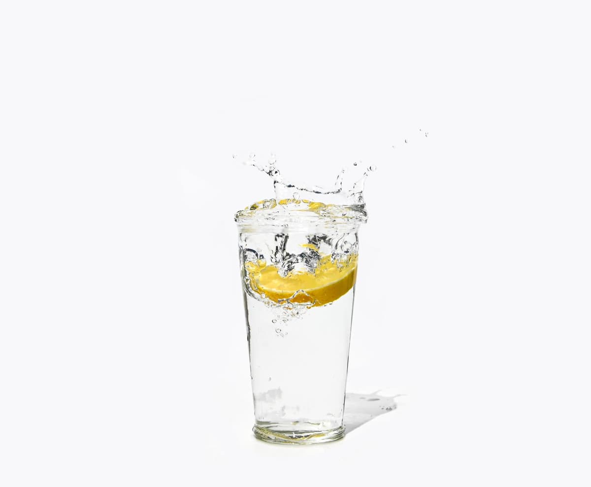 a single overflowing glass of bright yellow liquid