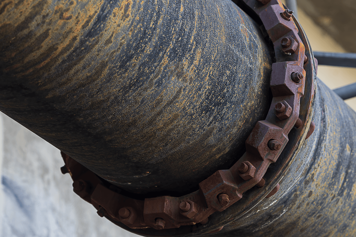a single rusted pipe supporting a massive marble skyscraper