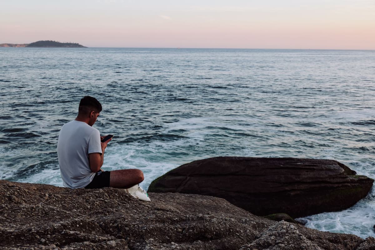a man trying to explain a smartphone to a literal rock