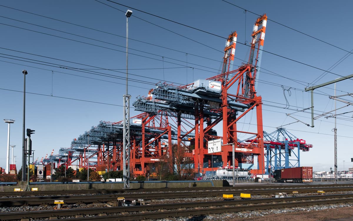 a high-speed freight train blurred by motion near a shipping port