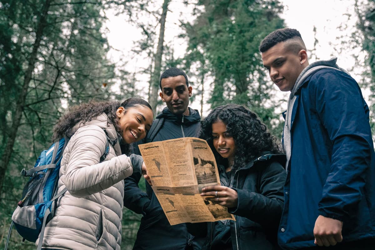 a person looking at a hand-drawn map in a forest clearing