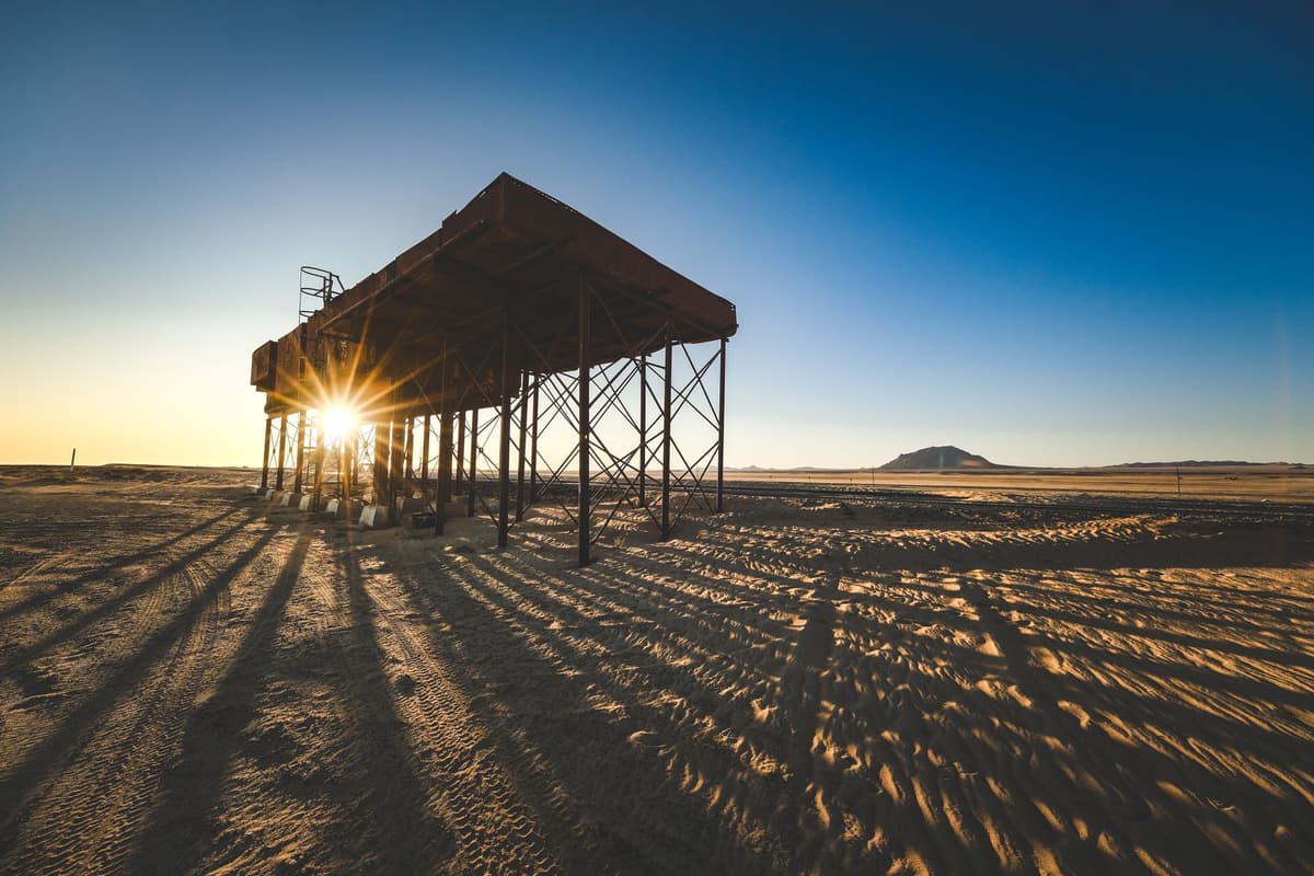 a massive steel vault door standing wide open in a desert