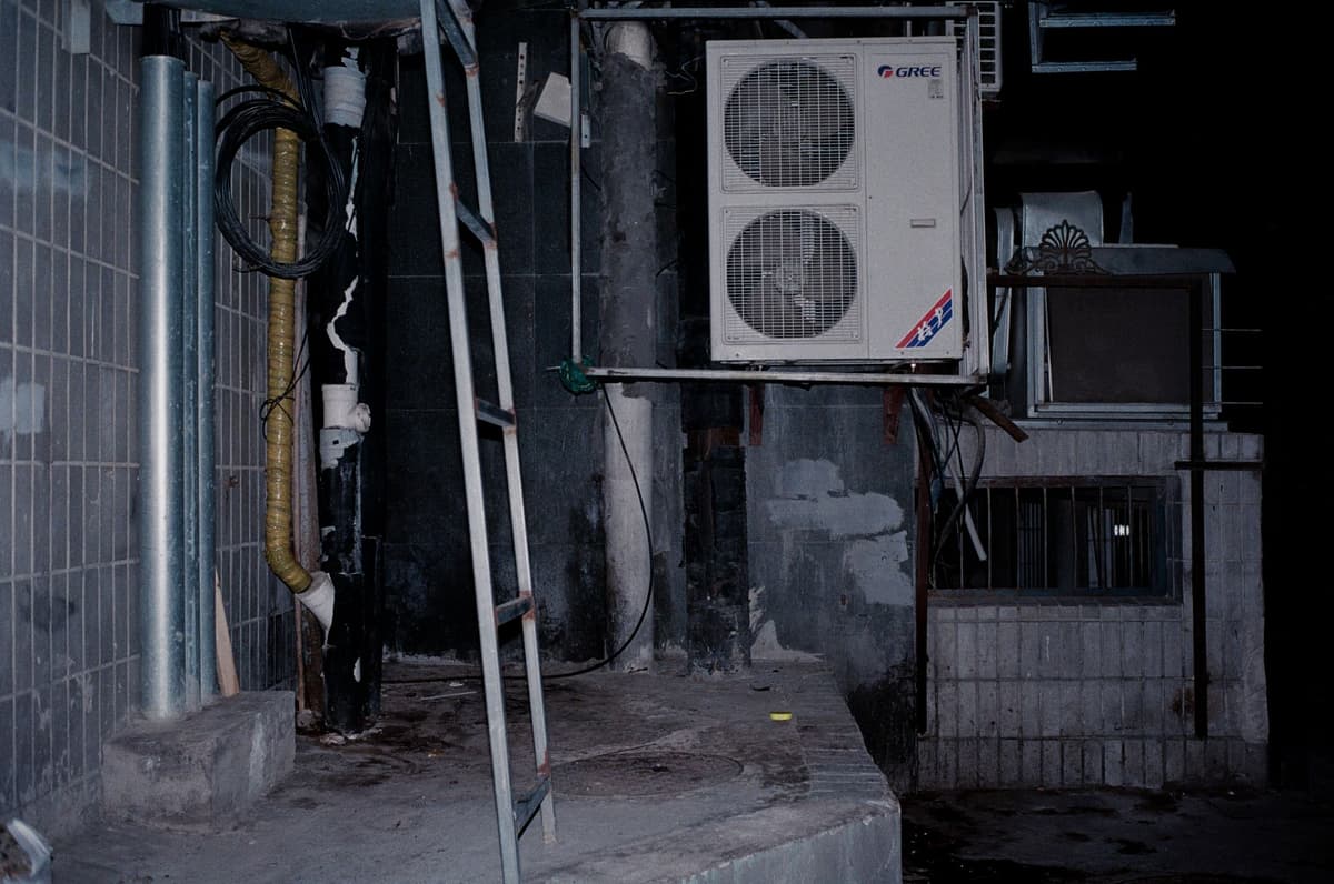a single dusty tomato next to a massive cooling pipe