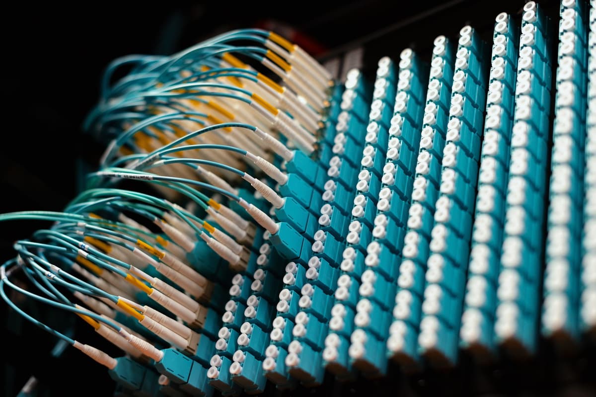 glowing fiber optic cables running into a dark server rack
