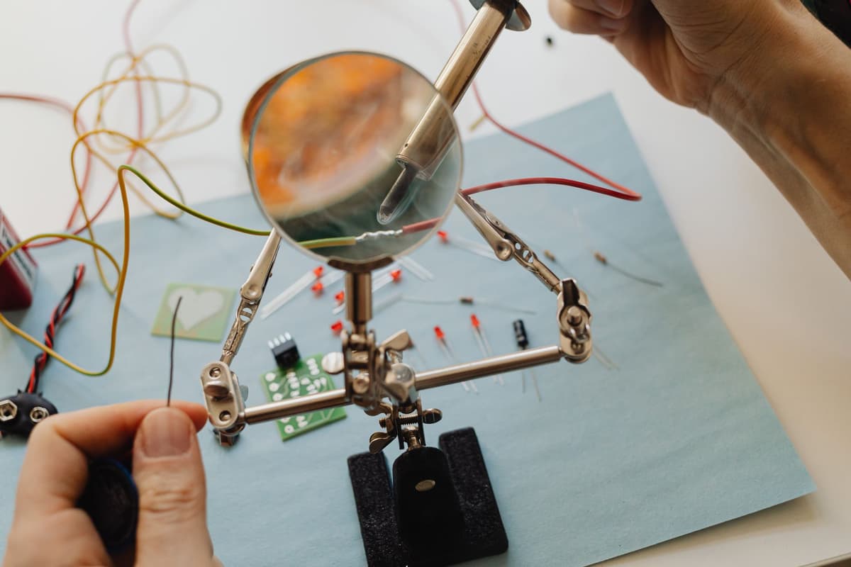 electronics engineer soldering microcontroller board at workbench