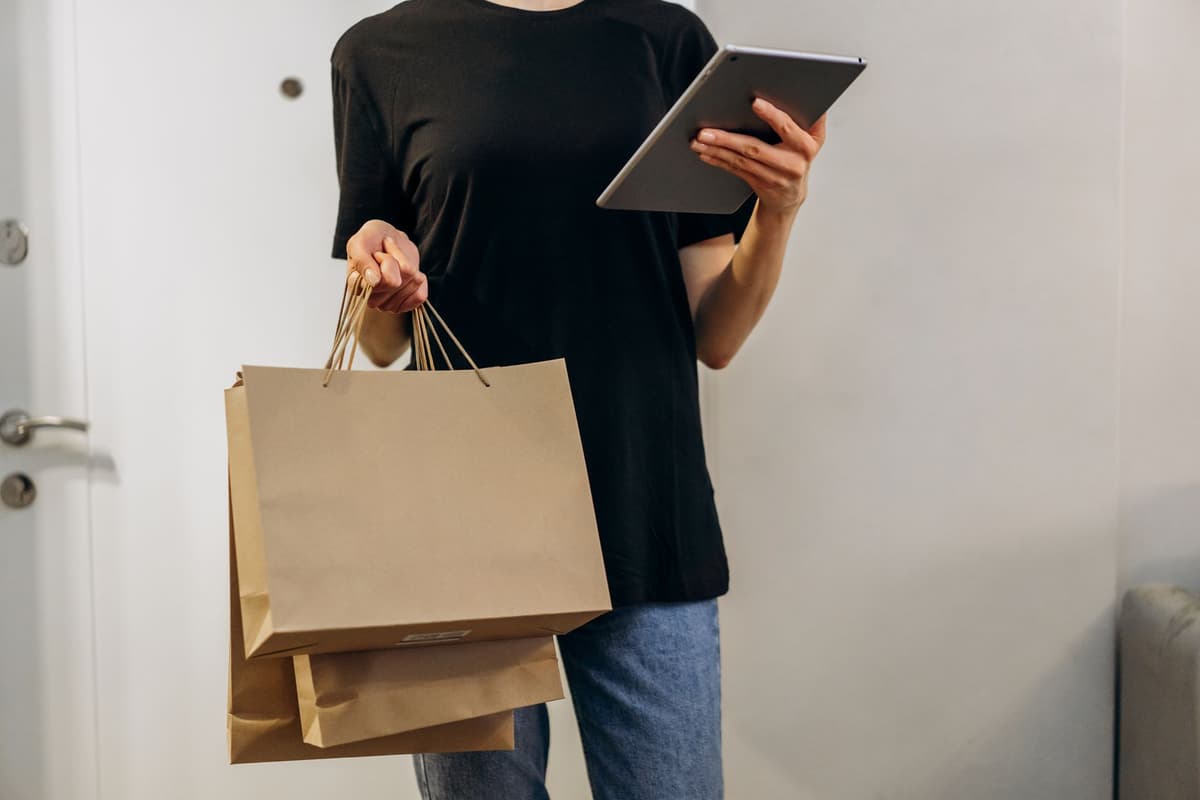 a person holding a grocery receipt next to a half-empty bag