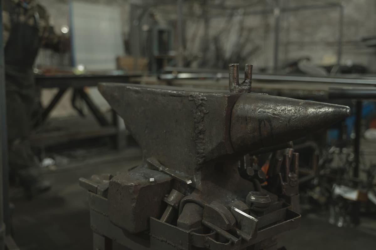a vintage alarm clock smashed by a heavy iron hammer