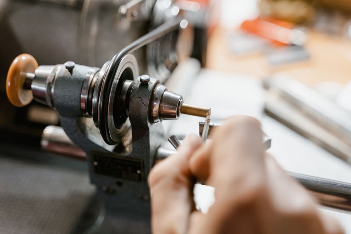 close up of a dusty hand crank on a wooden machine