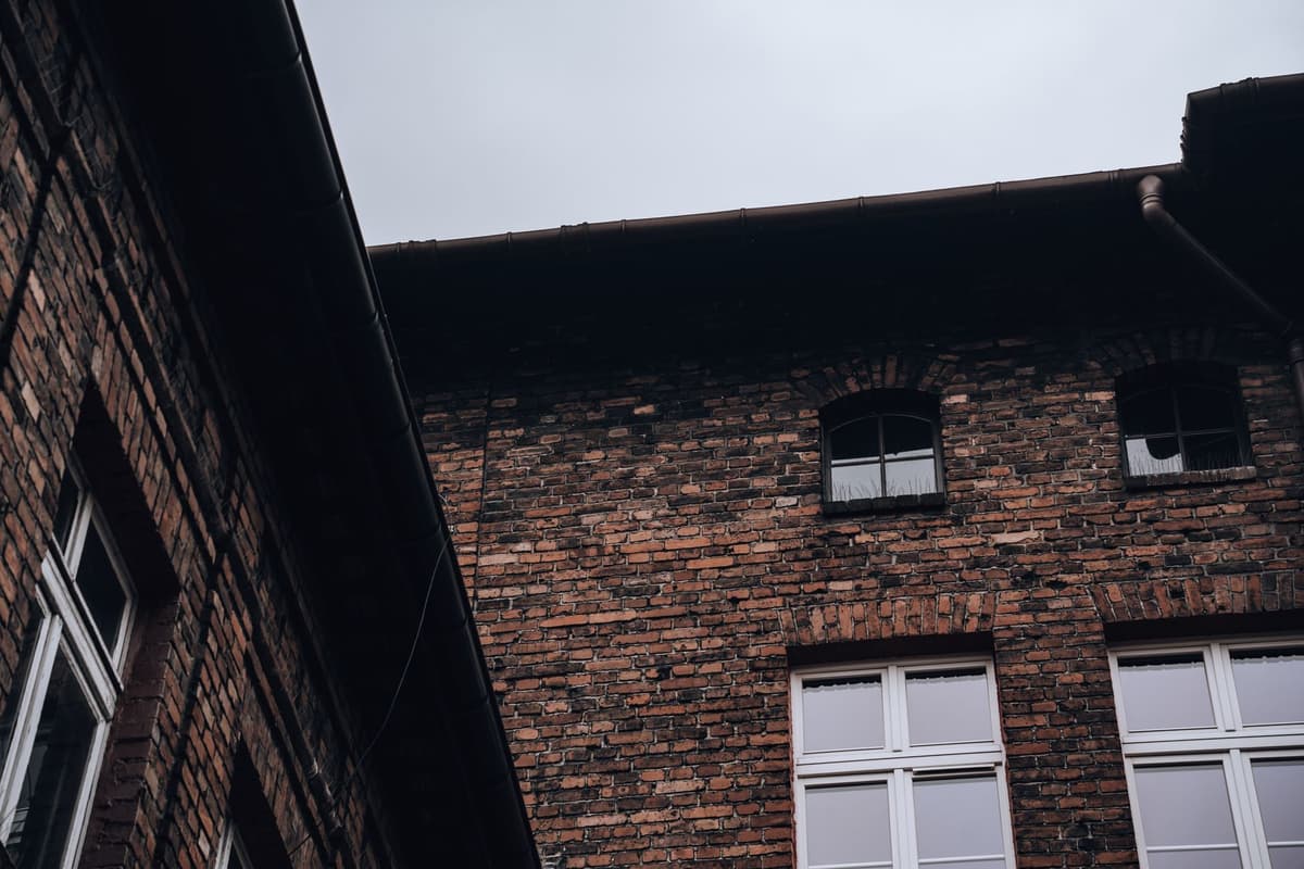 a single lit window in a dark brick building