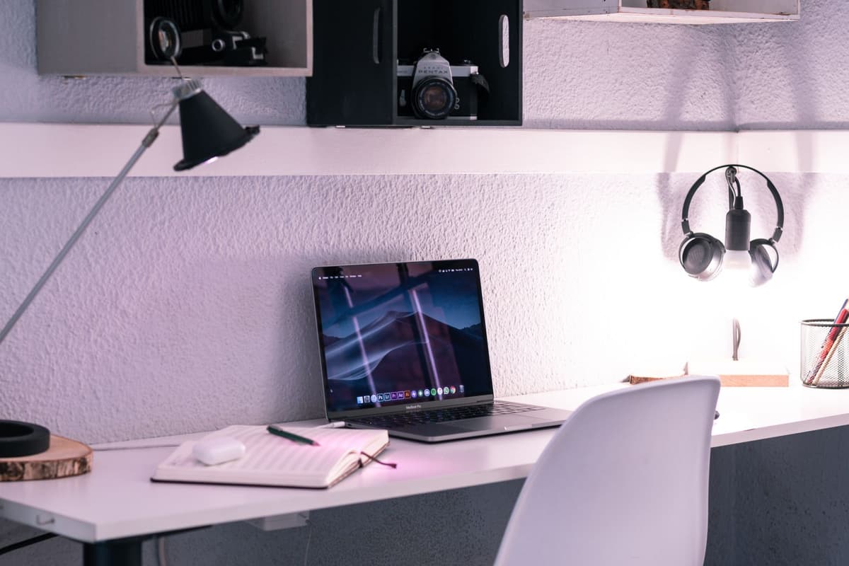 a pair of wireless earbuds resting next to a glowing laptop screen