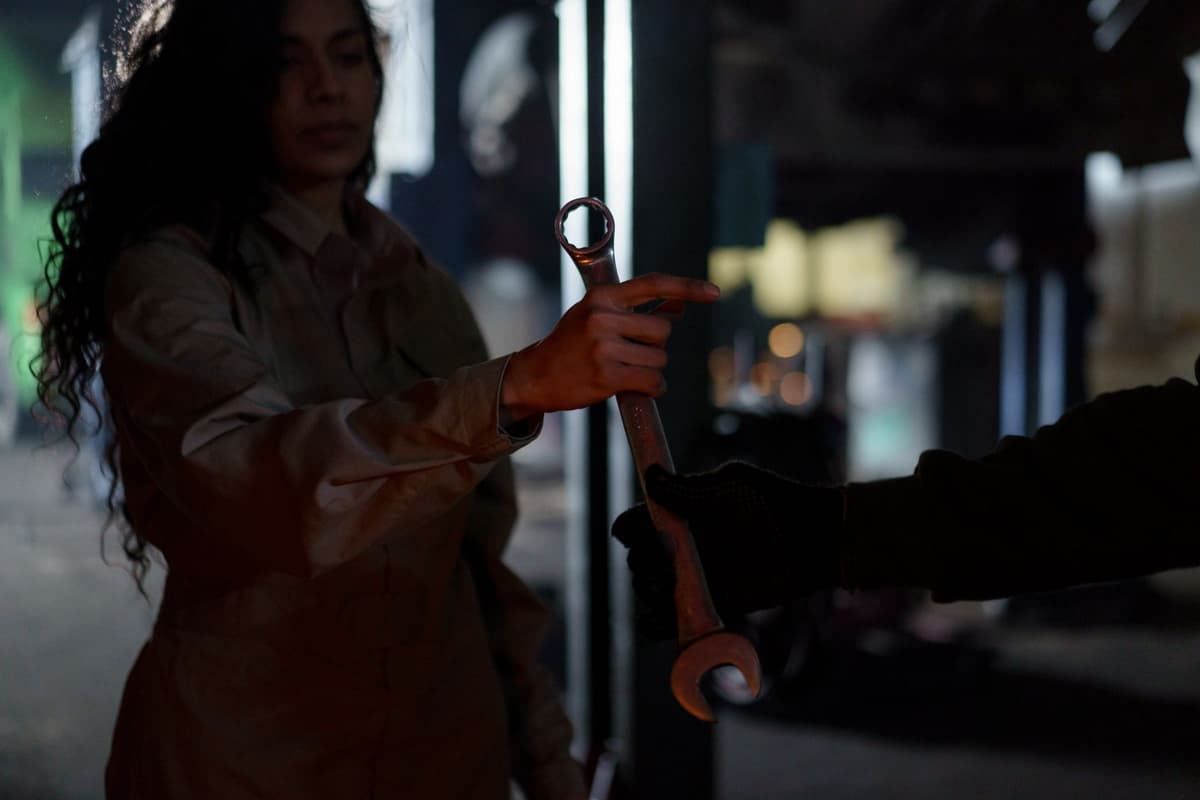 a scientist holding a massive wrench that is being pulled toward a glowing purple engine core