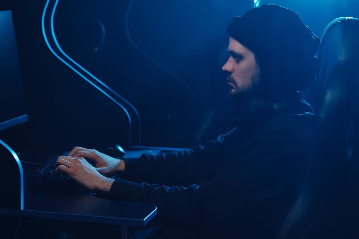 a man staring intensely at a green monochromatic computer monitor in a dark room