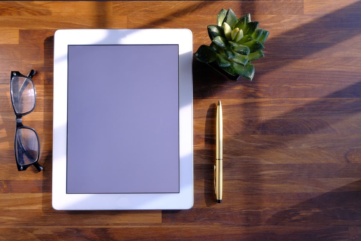 a single gray e-ink tablet sitting on a minimalist wooden desk