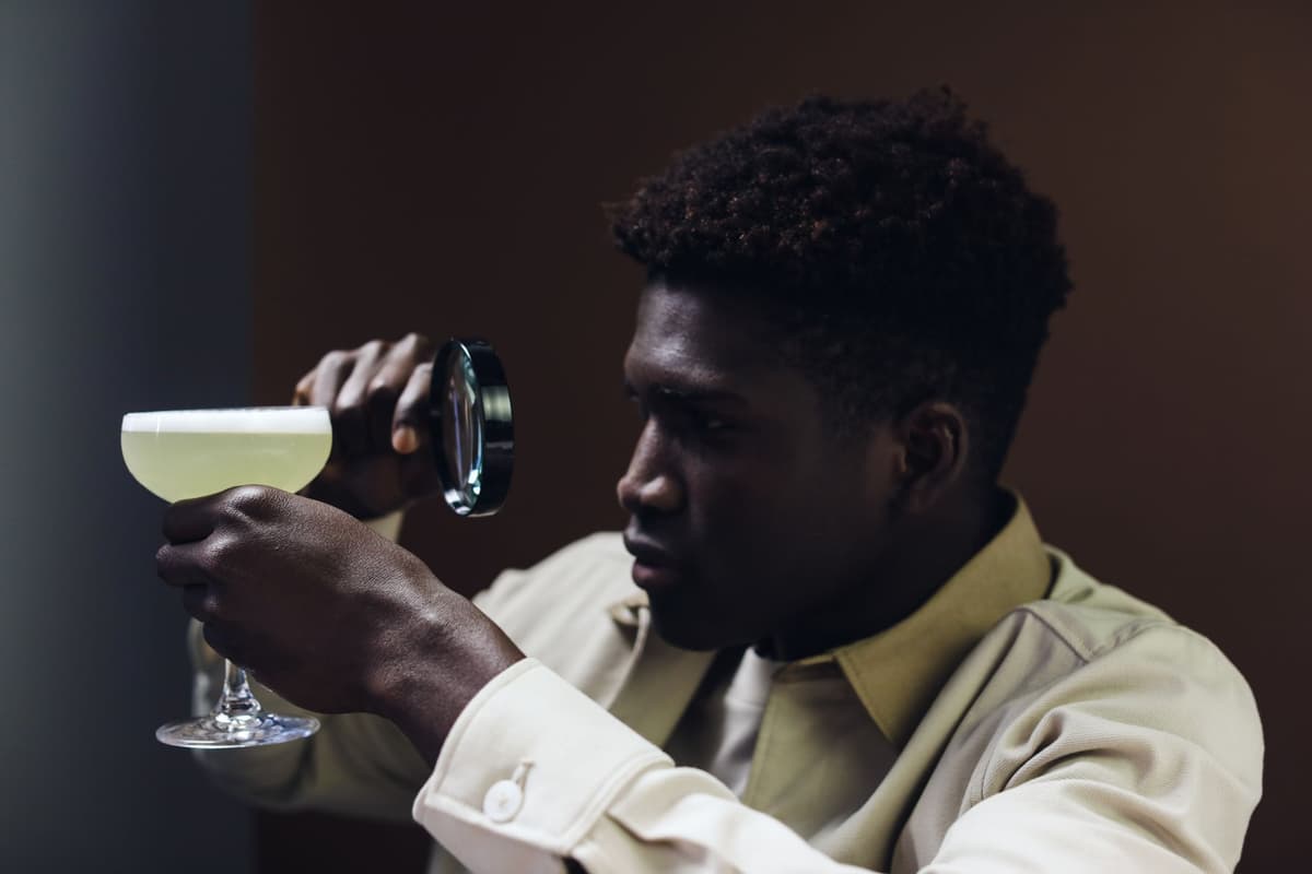 a man using a magnifying glass to inspect a single grain of rice