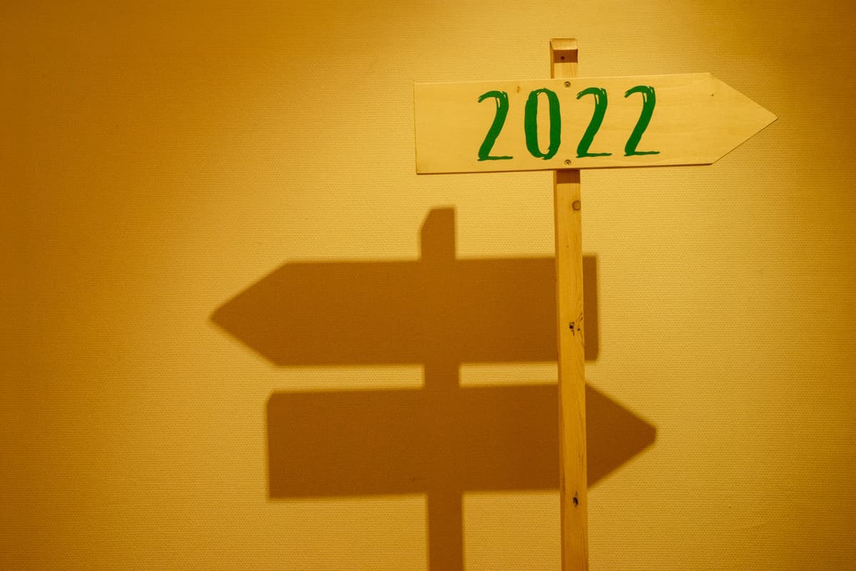 a faded wooden signpost with arrows pointing to different small towns