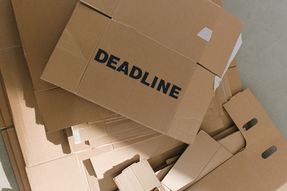 a dusty cardboard box labeled budget laptops in a dark warehouse