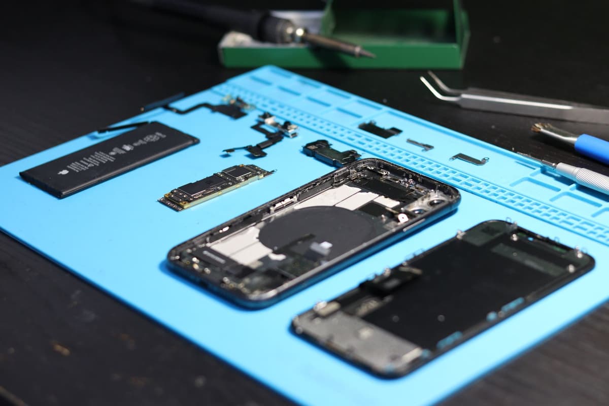 a disassembled smartphone motherboard under a powerful microscope
