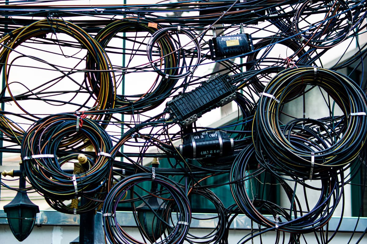 a dusty server rack with tangled colorful cables
