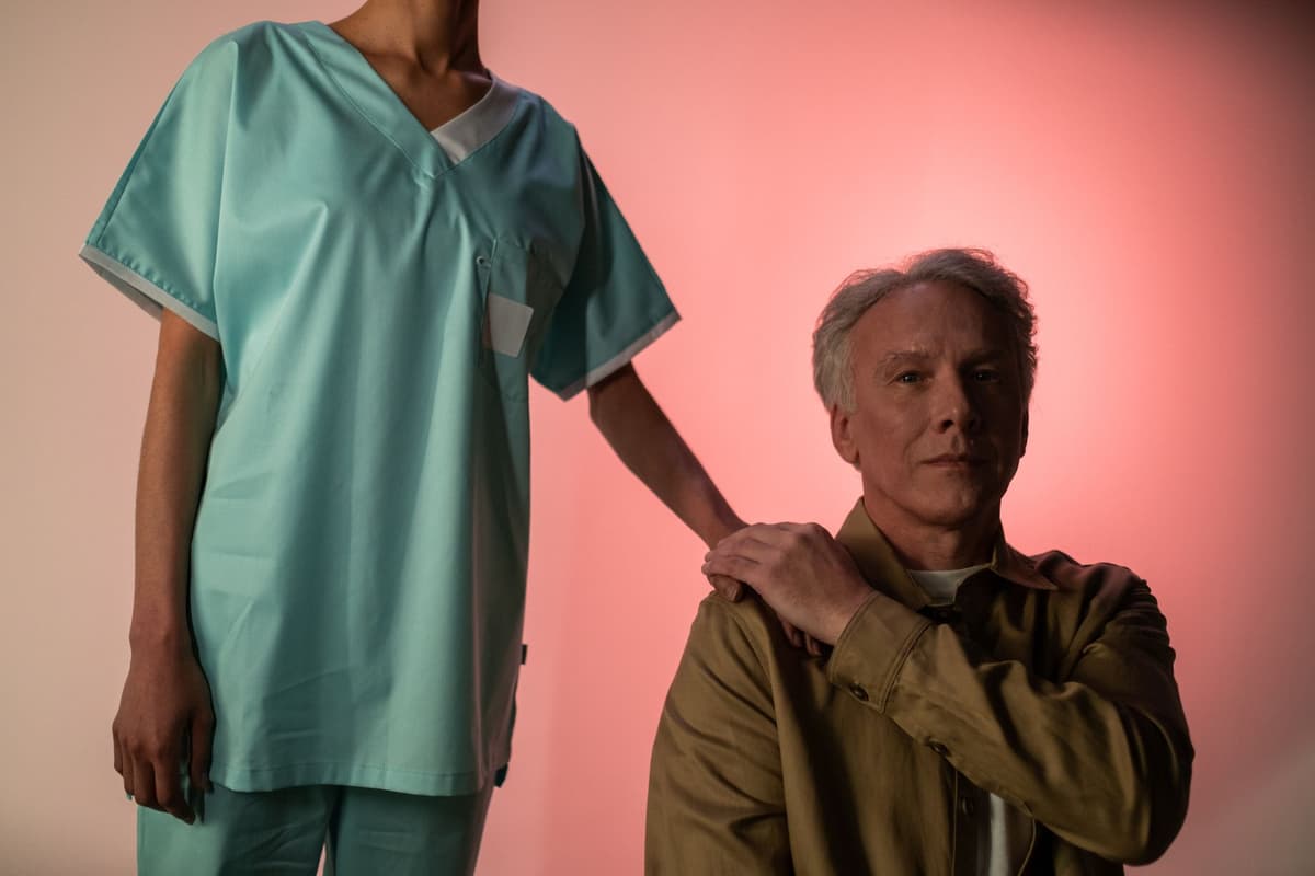 a health worker holding a smartphone close to an elderly man's eye