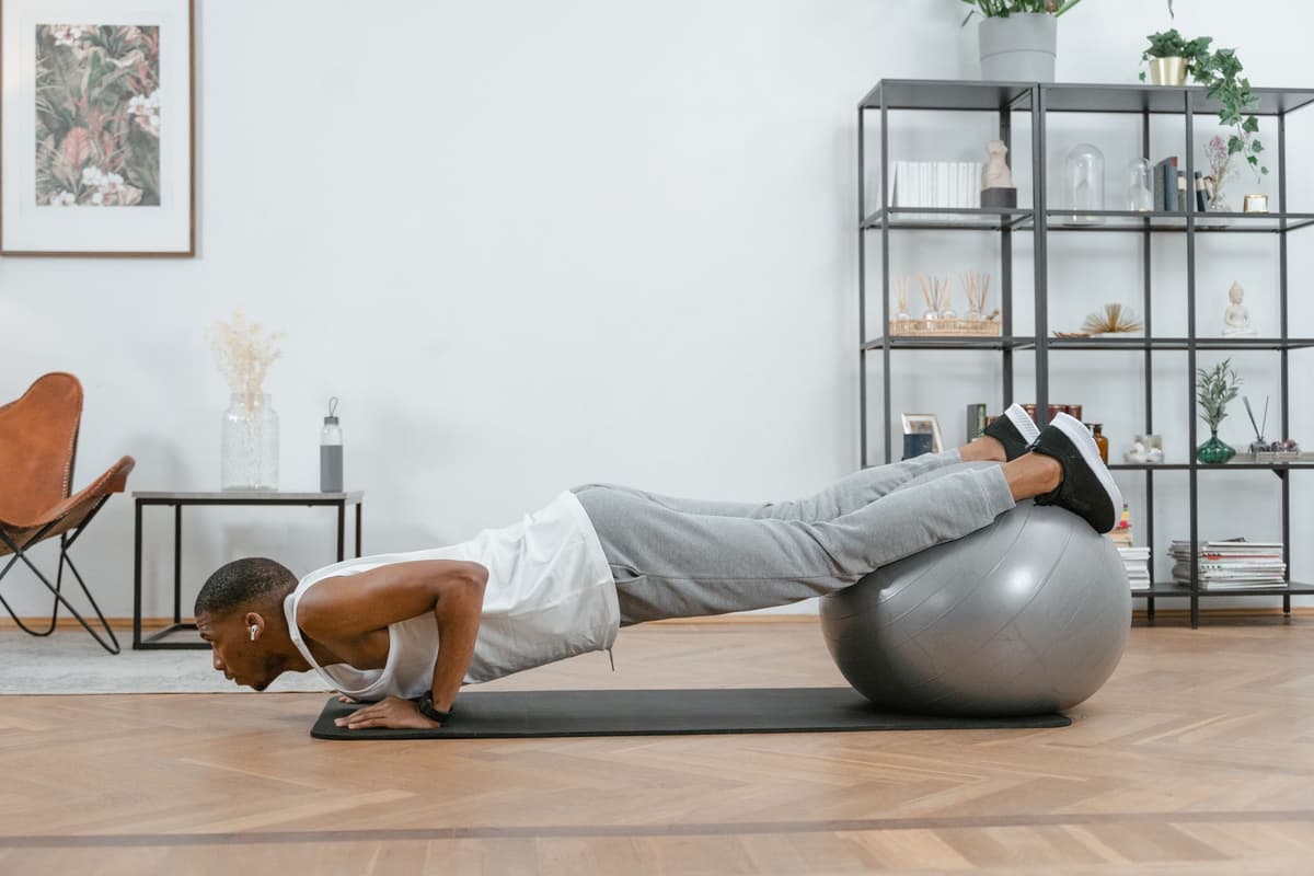 a man triumphantly holding a single sock while balancing on a yoga ball