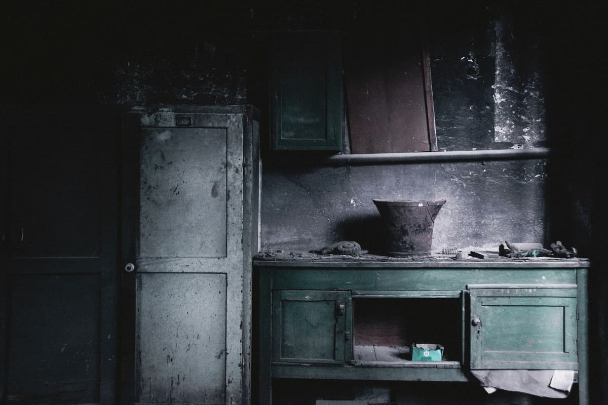 a dusty vintage filing cabinet with overflowing drawers