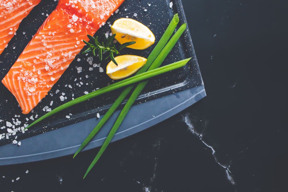 a raw trout on a dark stone slab