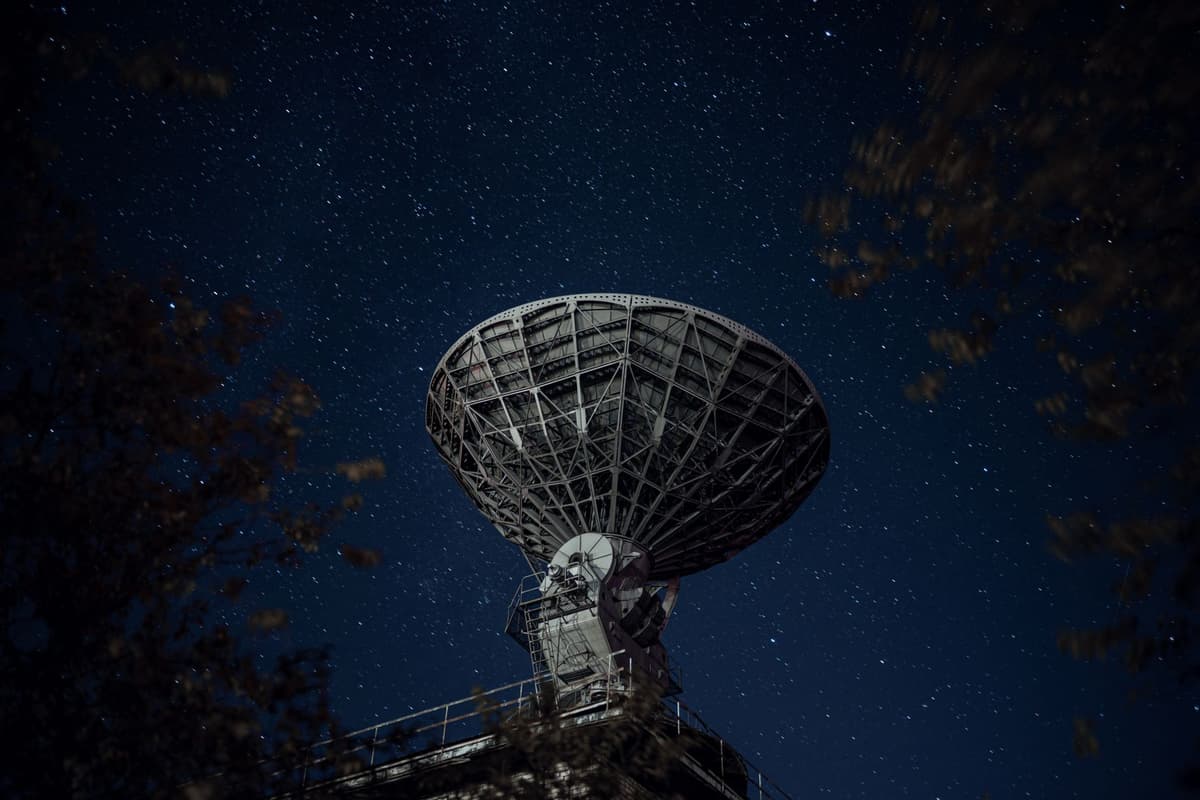 telescope dome open under night sky filled with faint stars