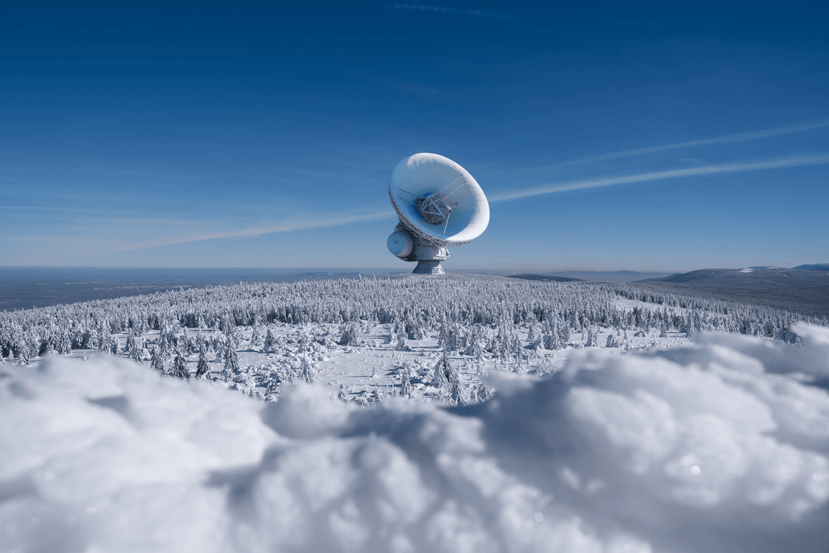 a small silver satellite dish reflecting a clear blue sky