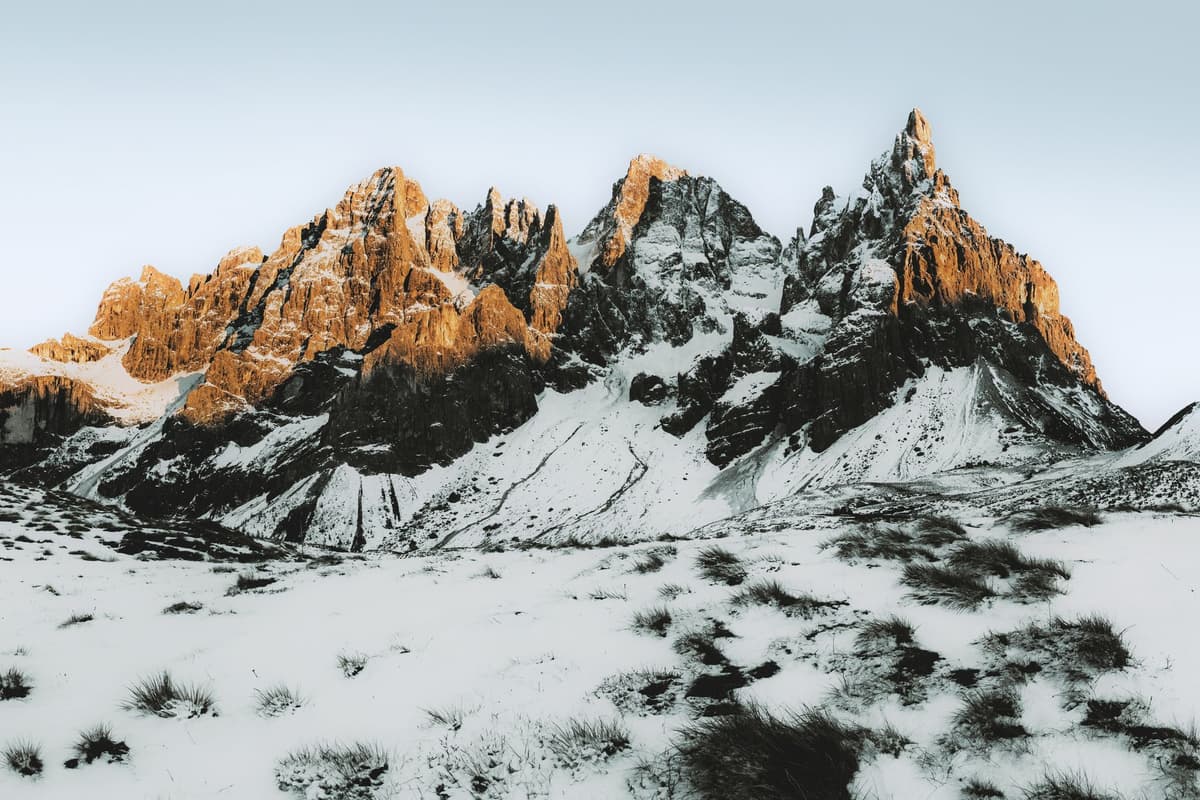 a single white rocket standing on a desolate snowy cliffside