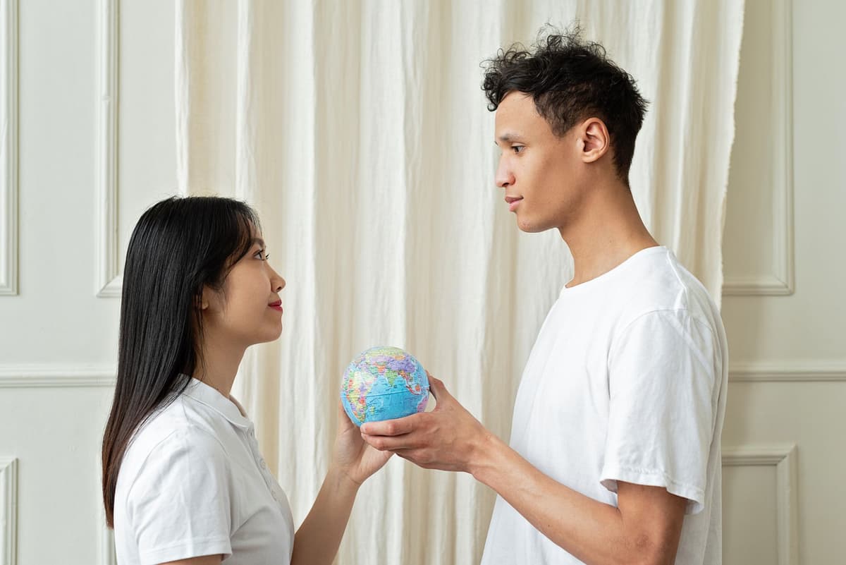 a man holding a tiny globe looking confused