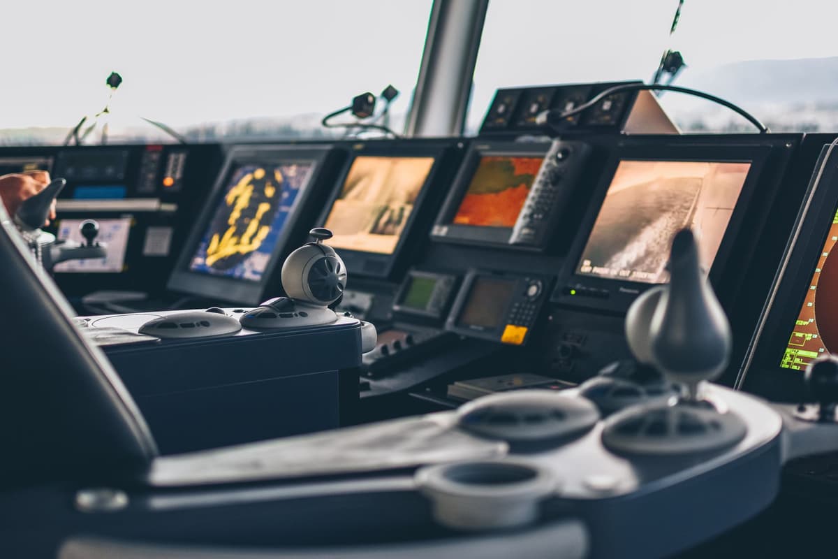 a control room with multiple screens showing industrial processes, slightly blurred with a sense of urgency