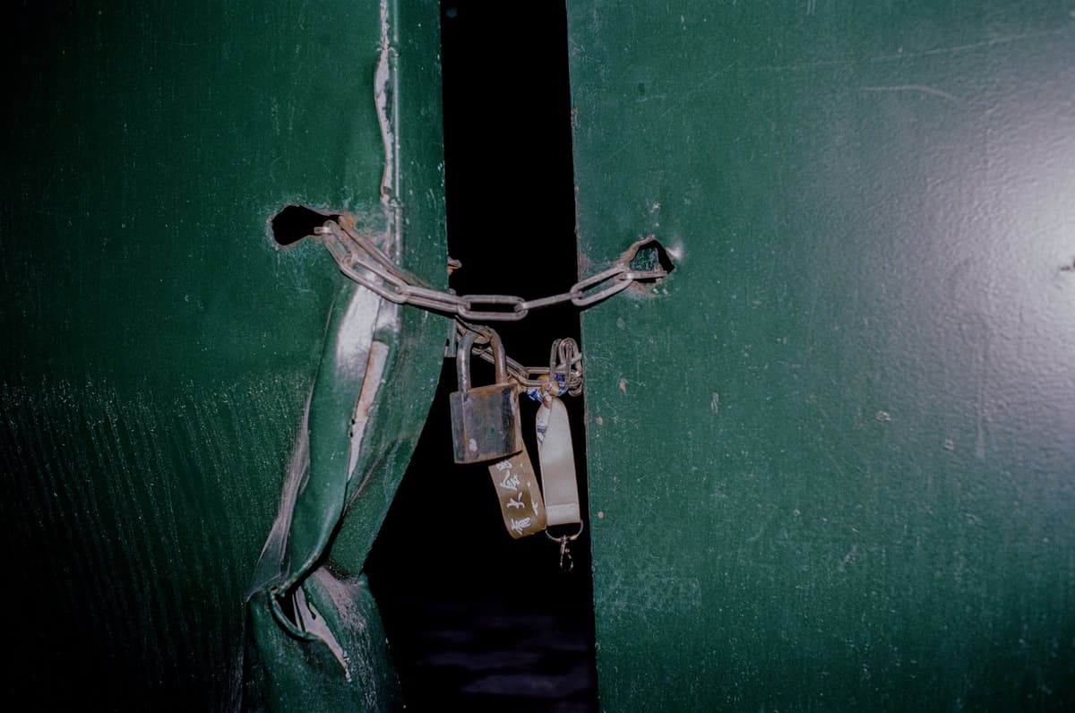a giant padlock wrapped in thick rusty chains on a server door